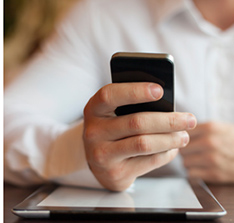 Image of a man holding an iPhone and an iPad.
