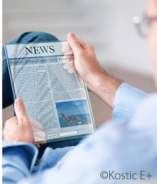 Man looking at a digital newspaper on a hightech tablet.